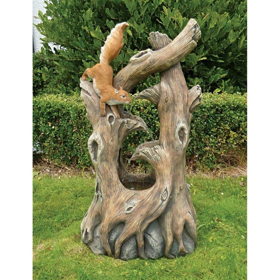 Squirrel plays on tree garden sculpture